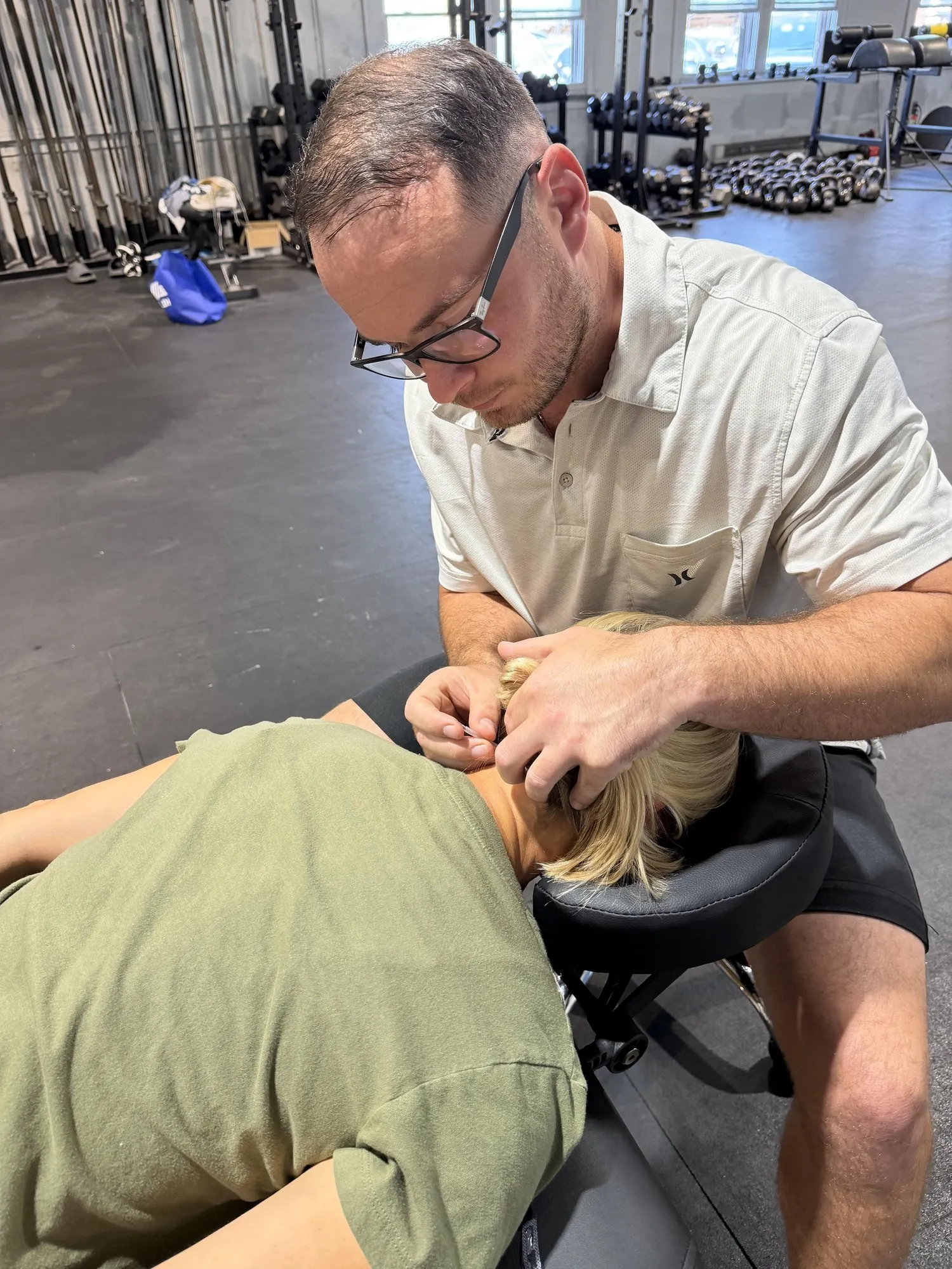 Dr. Kyle McIntyre dry needling a client's upper back and neck