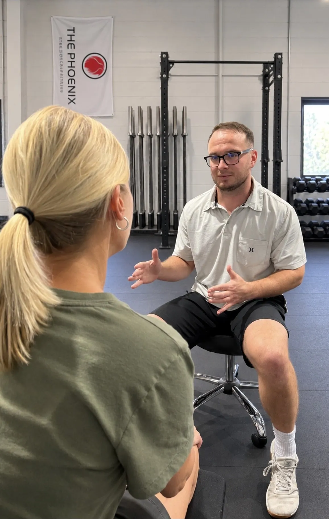 Kyle seated, talking with a client during a visit