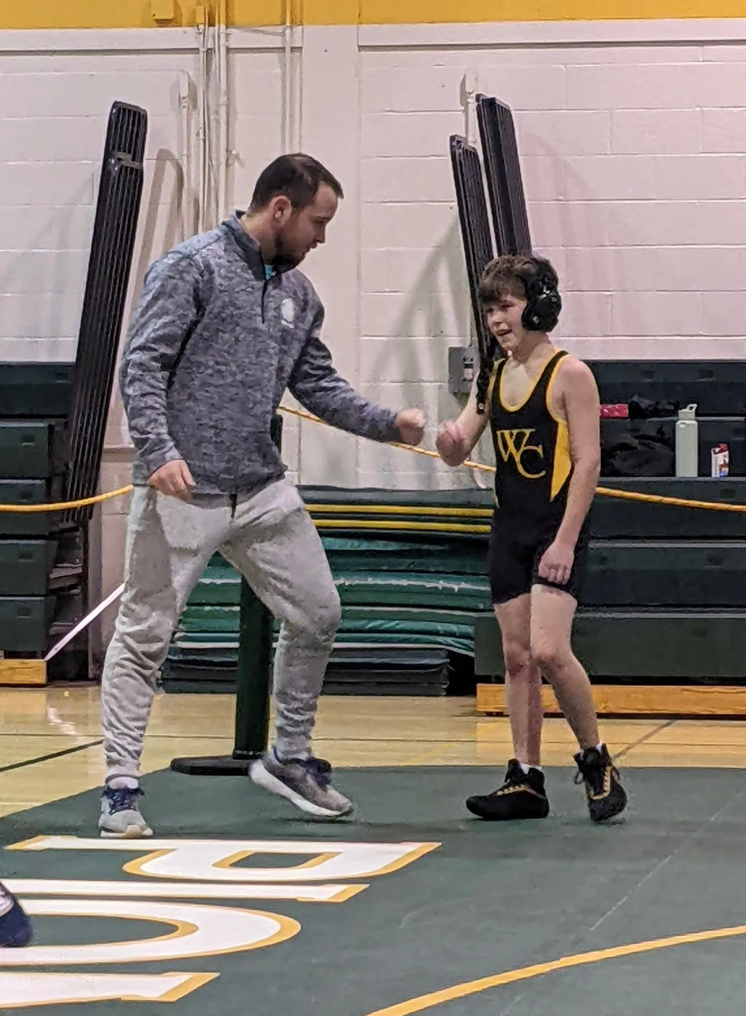 Kyle working with a young wrestler at practice
